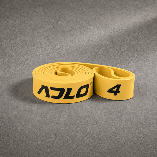 ADLO #4 Band - moderate to heavy resistance gold natural latex resistance band coiled on concrete