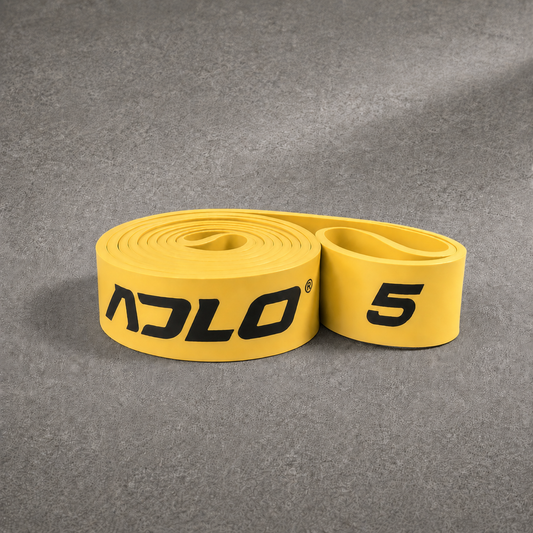 ADLO #5 Band - heavy resistance gold natural latex resistance band coiled on concrete